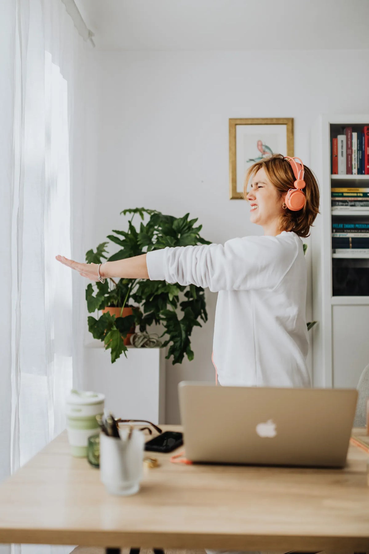 Eine Frau steht am Arbeitsplatz auf und streckt sich. Foto: https://kaboompics.com/ / Pexels.