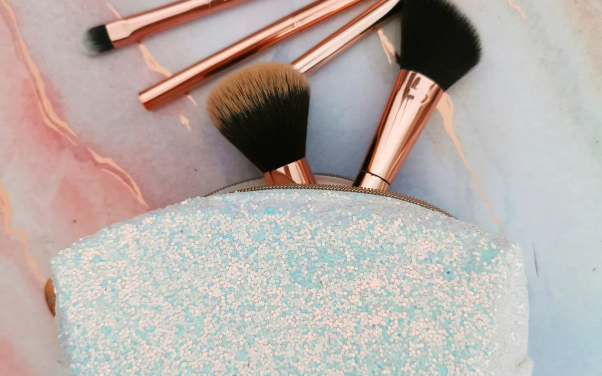 Kosmetiktasche mit Make-up-Pinseln auf einer hellen Oberfläche. Foto: Nadia Dolce / Pexels.