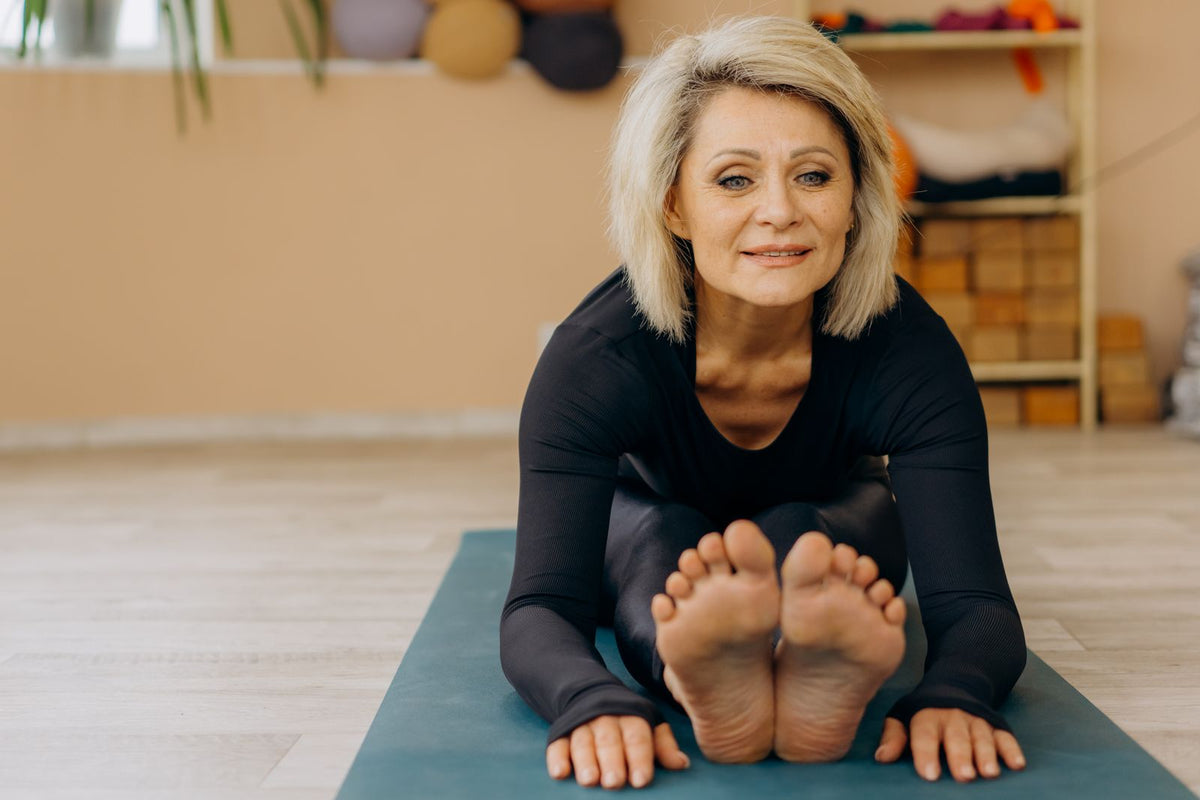 Ältere Frau übt Yoga in einem hellen Raum