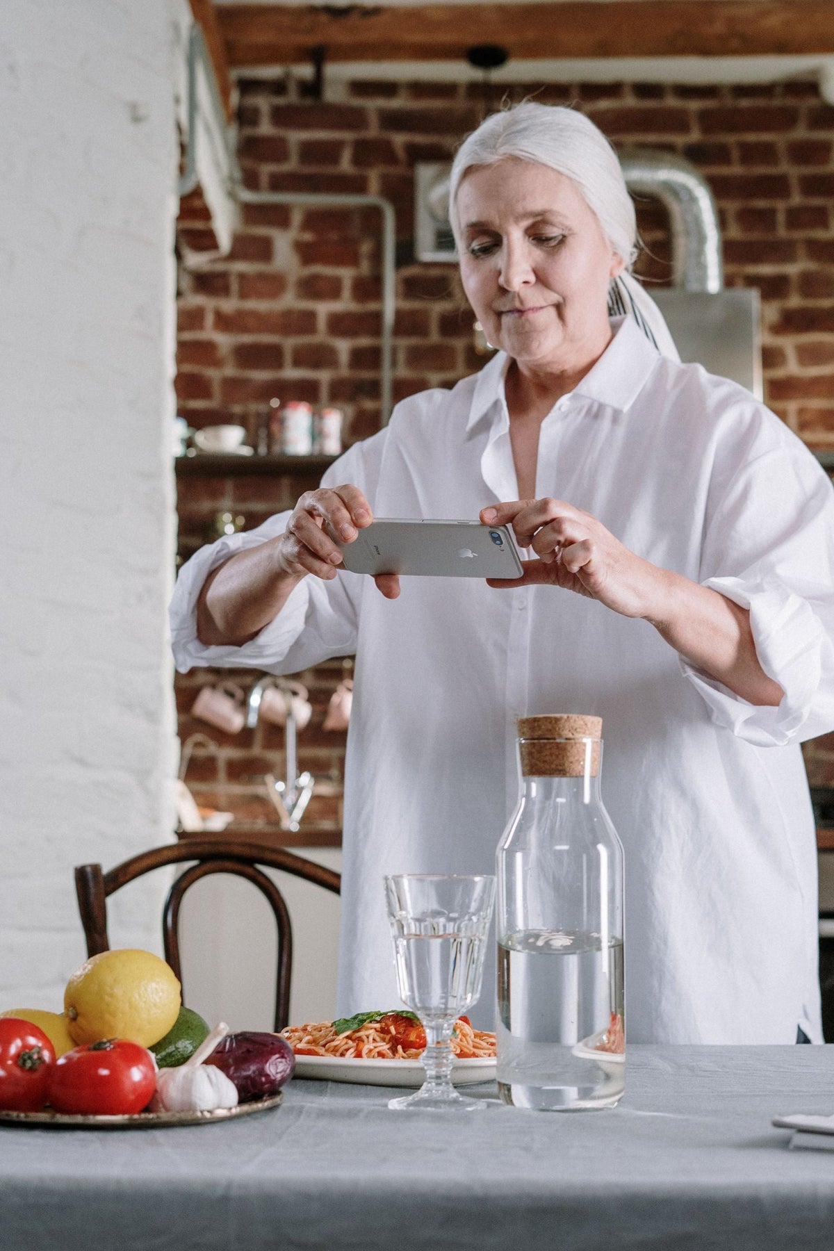 Frau an einem Tisch mit einer frisch zubereiteten Mahlzeit