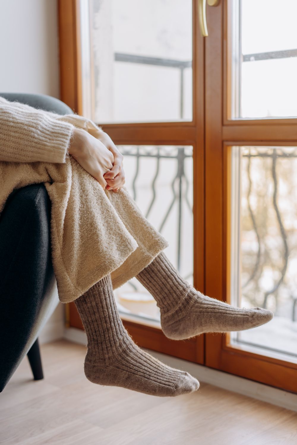 Warme Socken an den Füßen einer Person auf einem Sofa