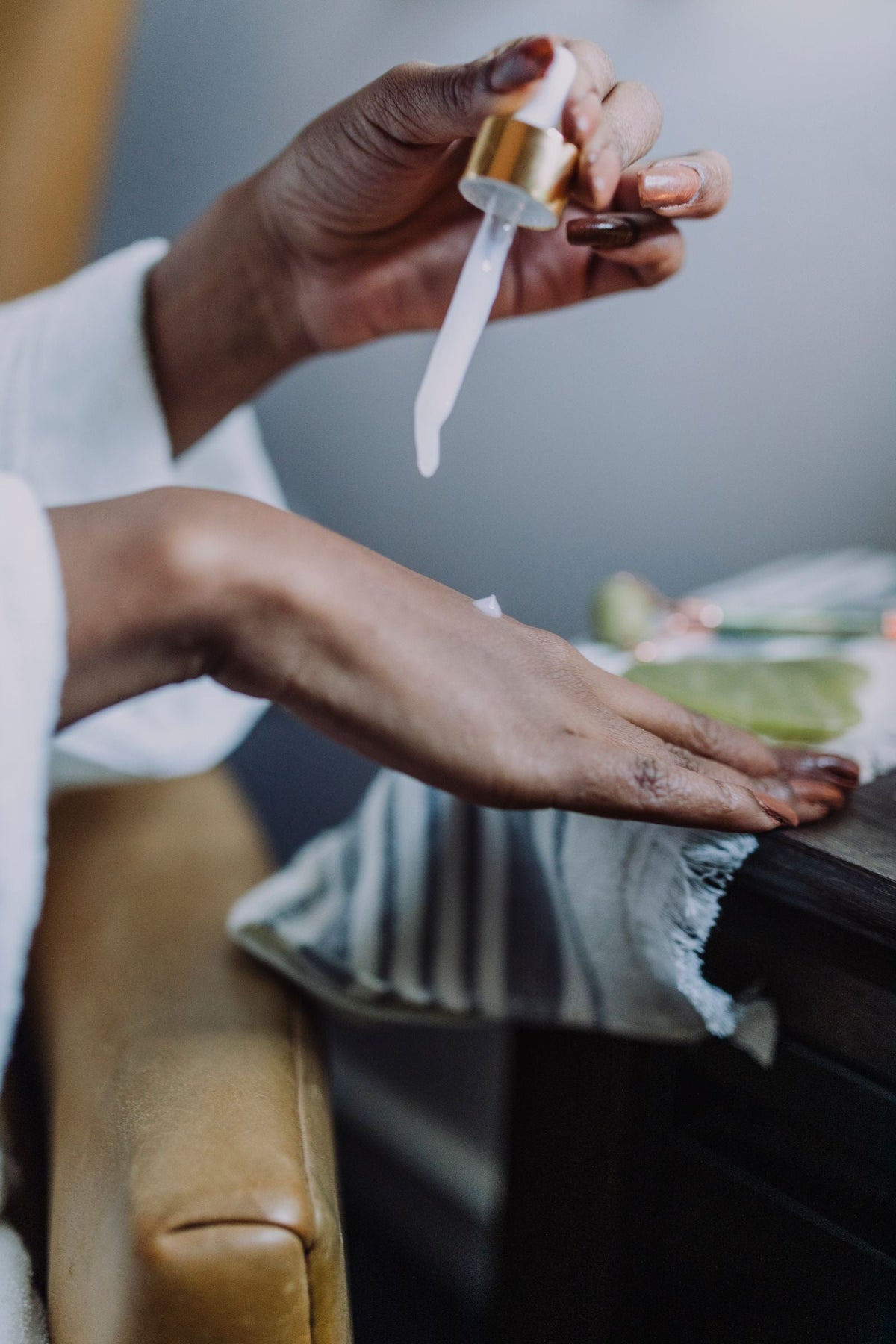Kosmetik wird mit einer Pipette auf eine Hand aufgetragen