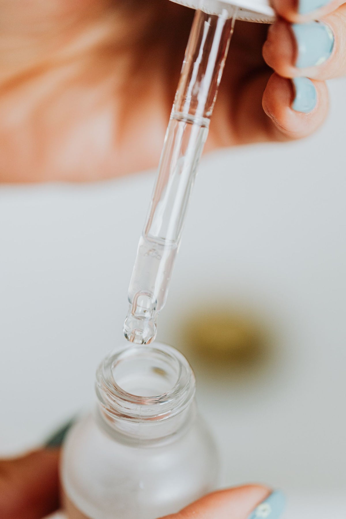 Pipette über einem Kosmetikfläschchen