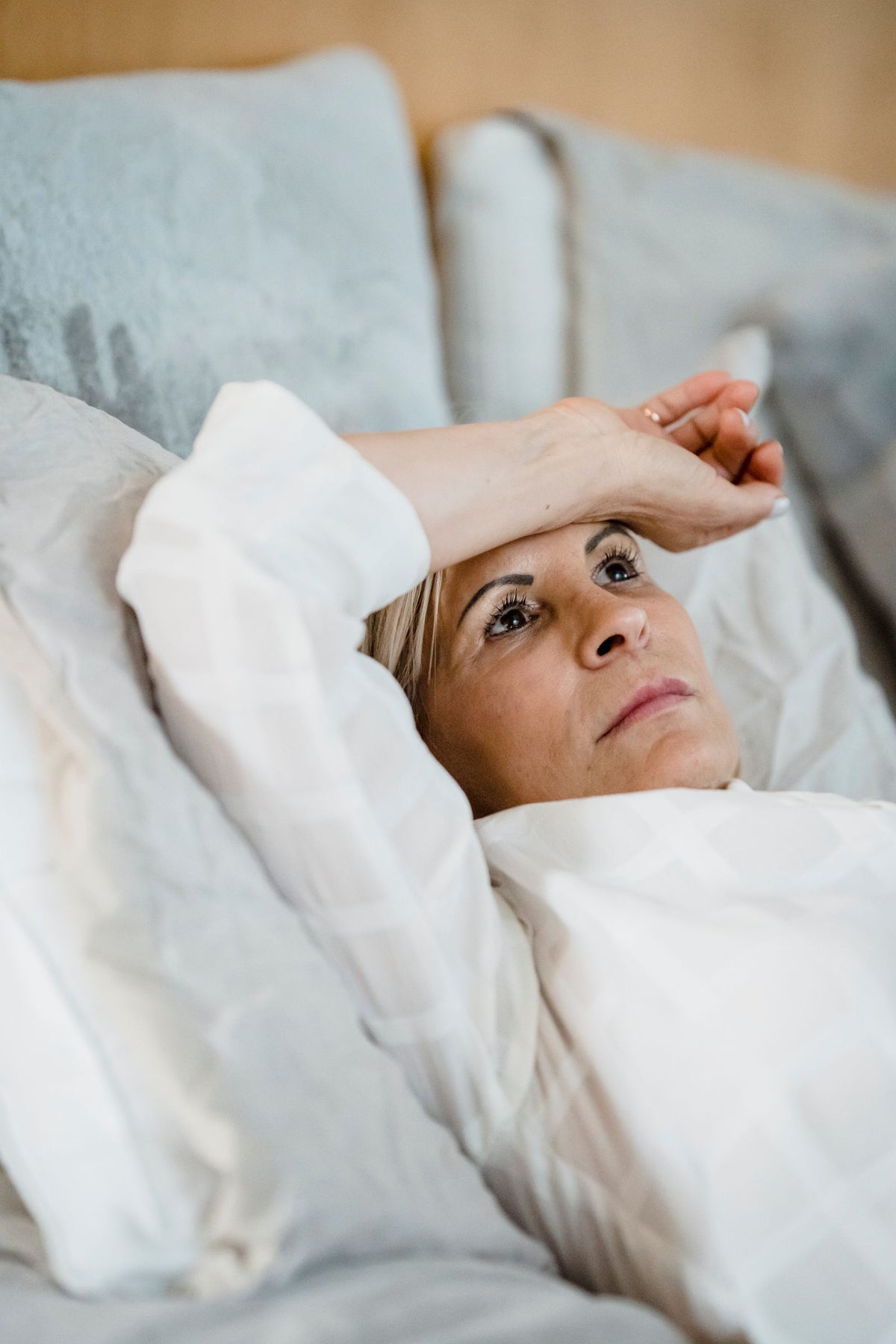Frau liegt nachdenklich im Bett