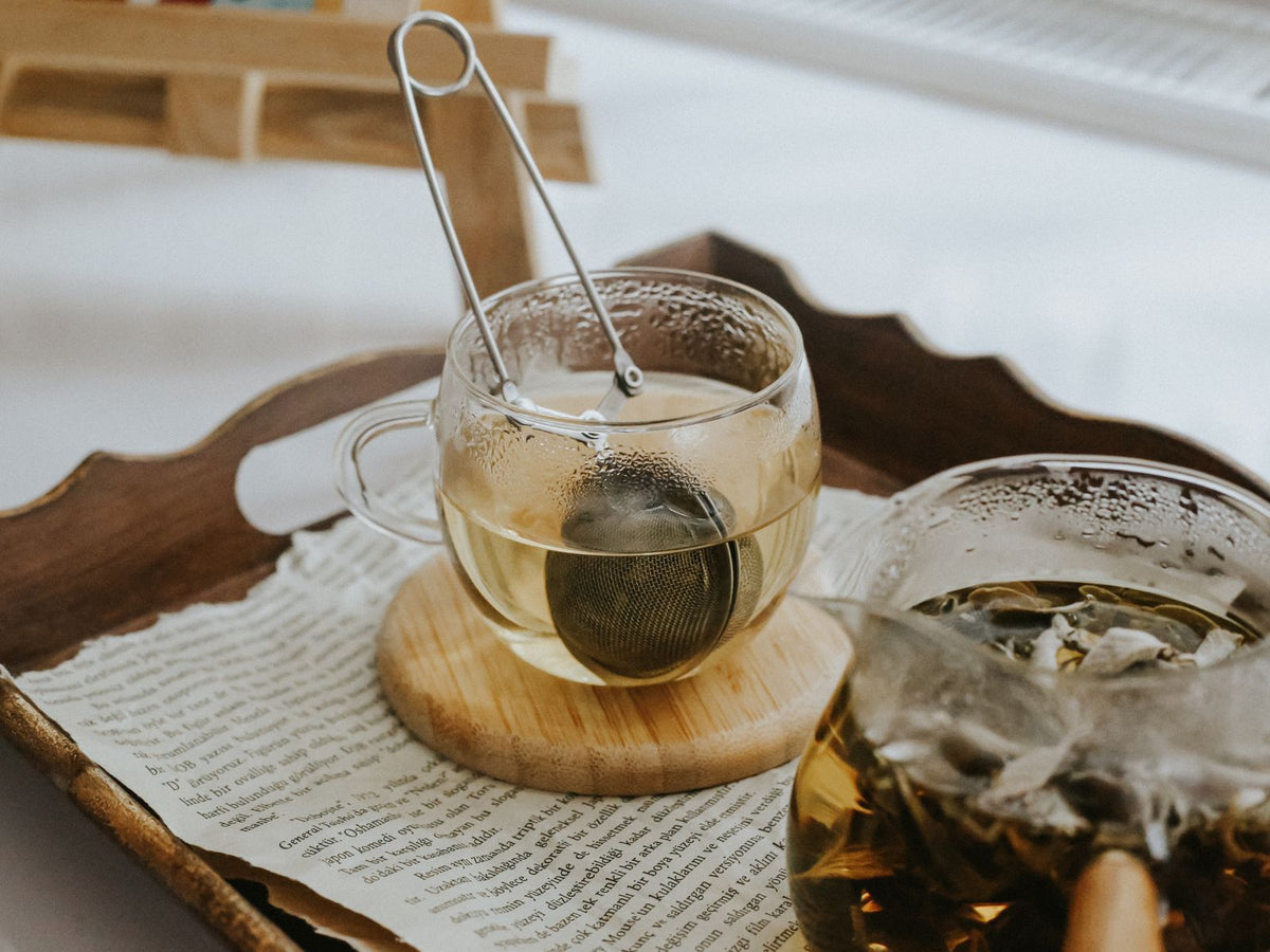 Tee in Glastassen mit Teesieb – Illustration zur Kräuteranwendung