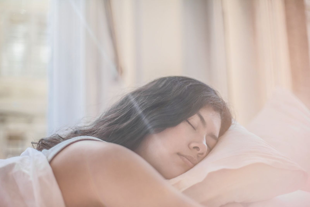 Frau ruht im Bett im weichen Morgenlicht
