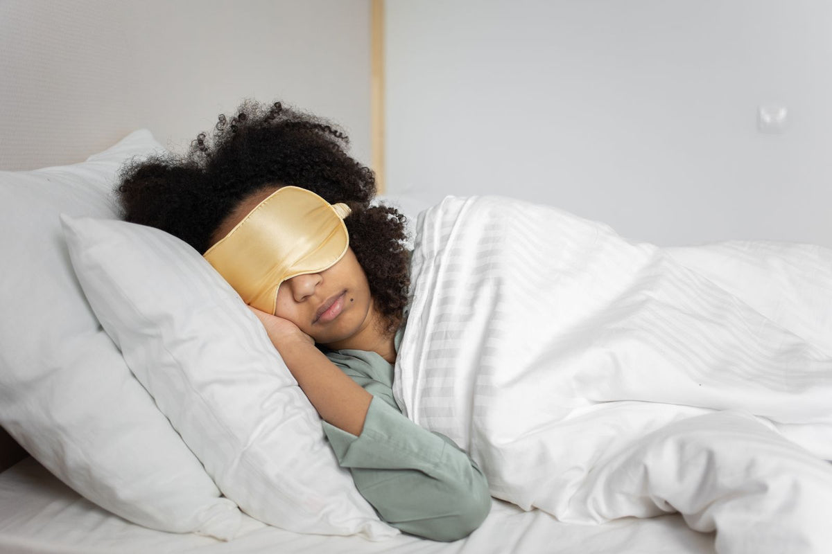 Frau entspannt im Bett mit einer Schlafmaske
