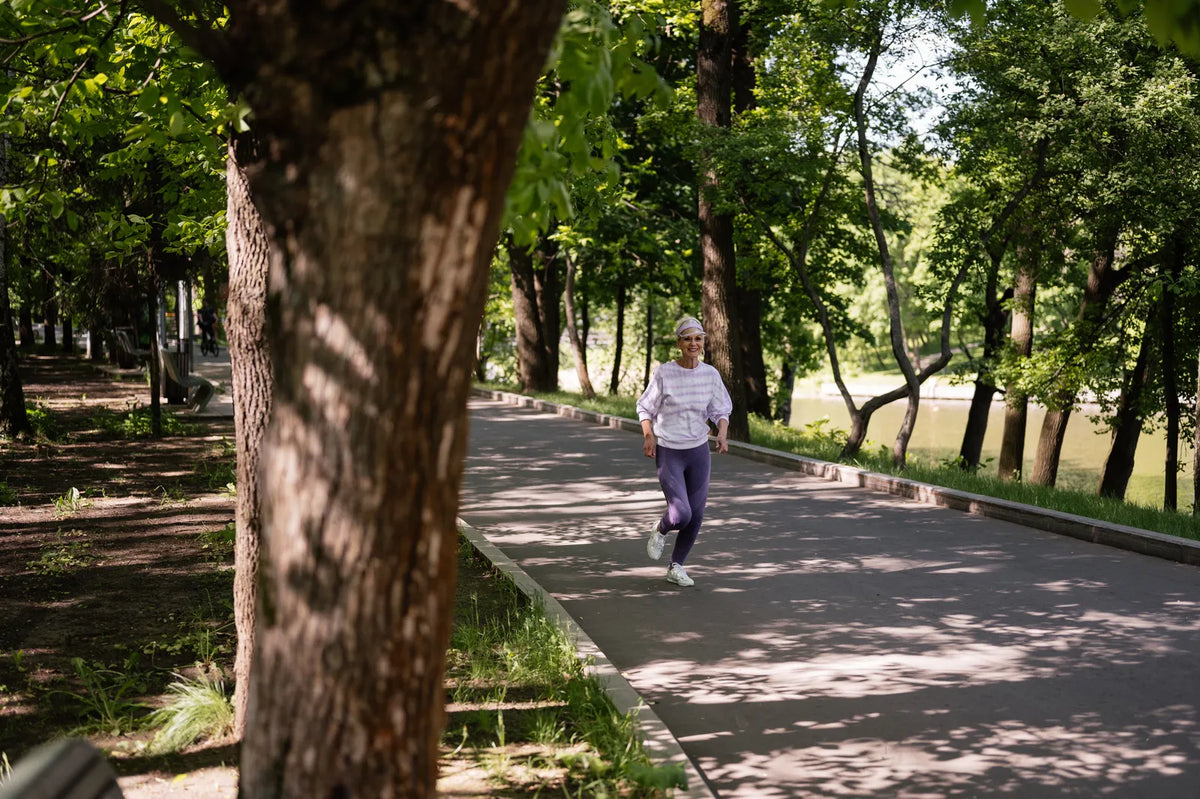 Eine Frau läuft auf einem grünen Parkweg. Foto: SHVETS production / Pexels.