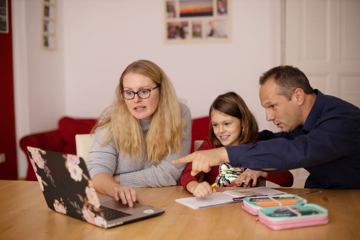 Eltern unterstützen ihre Tochter beim Lernen zu Hause