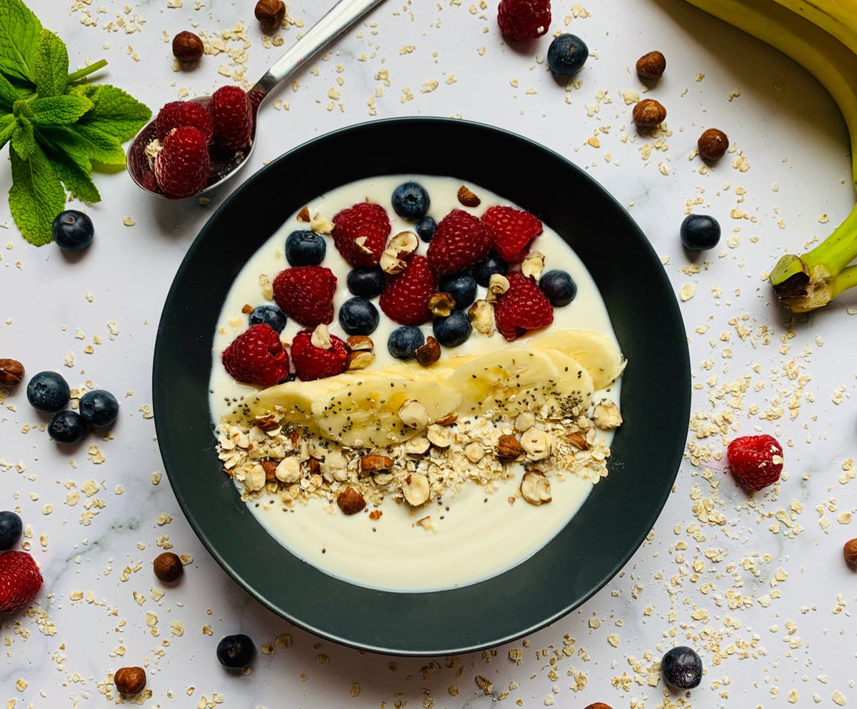 Naturjoghurt mit Beeren, Banane und Nüssen auf einem Teller