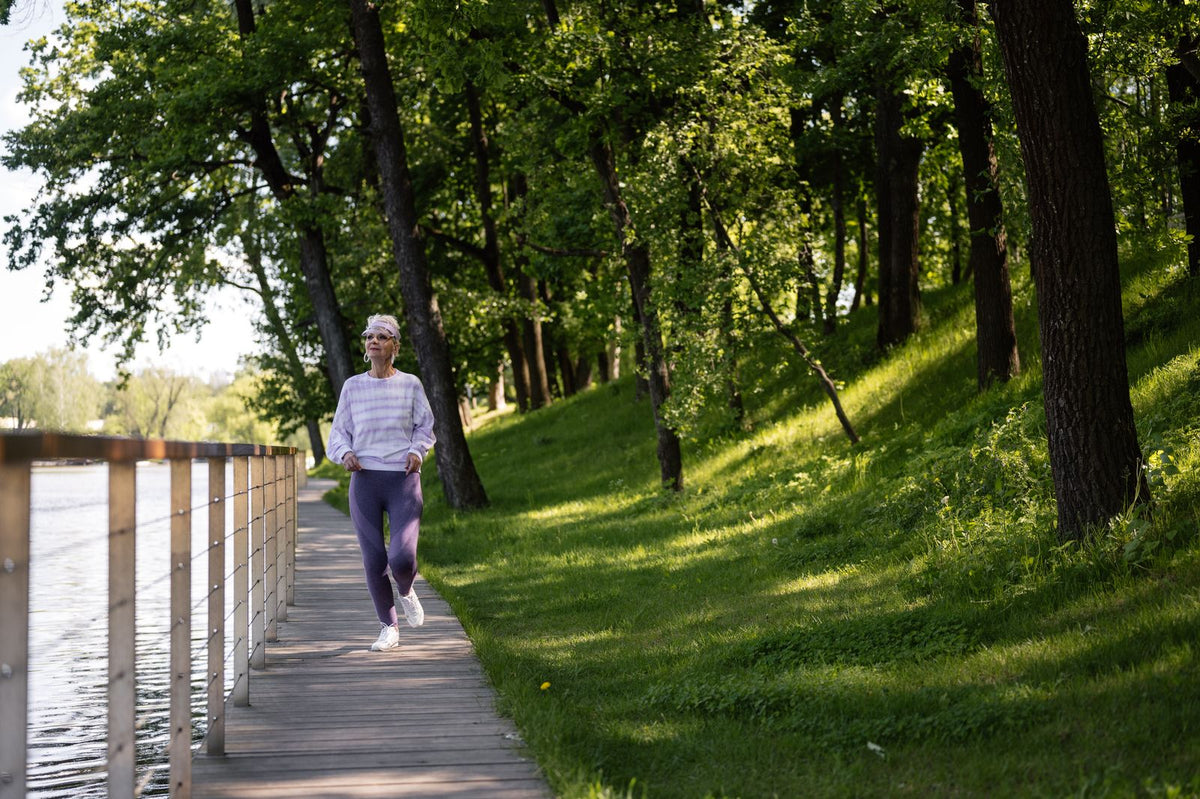 Frau bewegt sich auf einem Weg im grünen Park