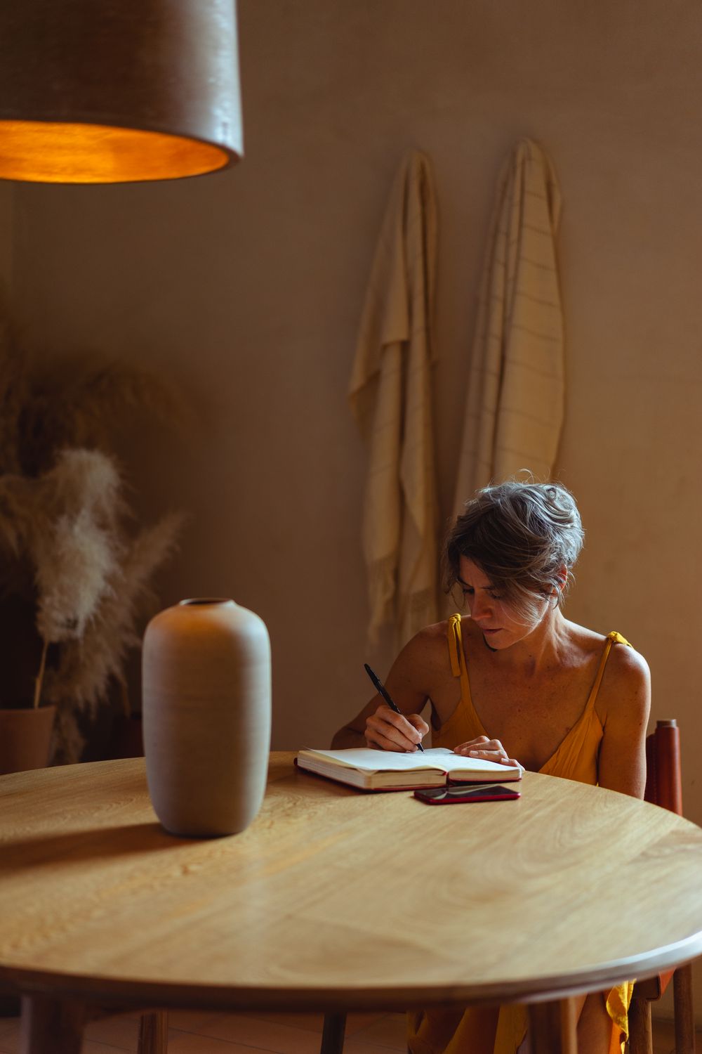 Frau schreibt zu Hause in ein Notizbuch