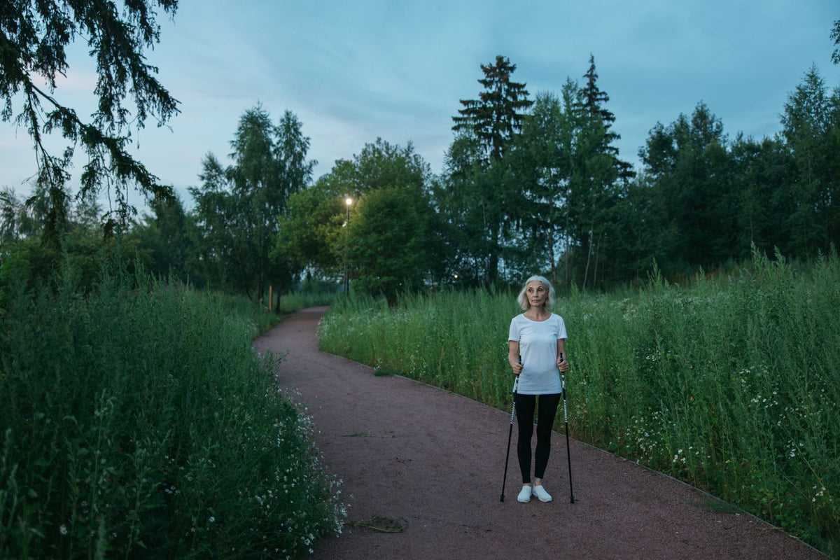Frau mit Walkingstöcken im Park